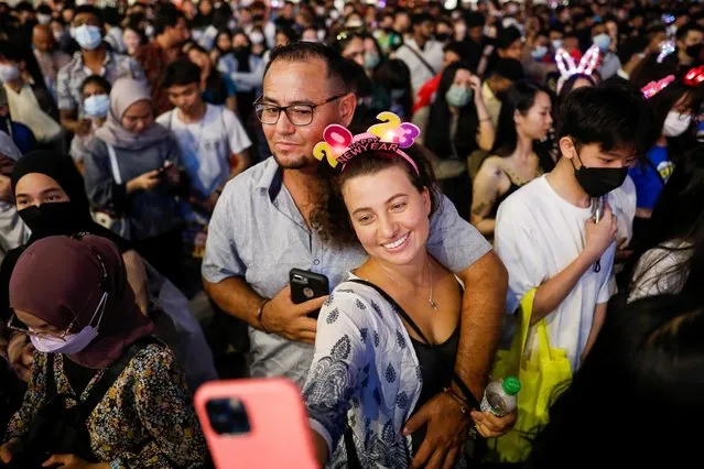 A couple takes a selfie as they celebrate New Year's Eve in Kuala Lumpur, Malaysia on December 31, 2022. (Photo by Hasnoor Hussain/Reuters)