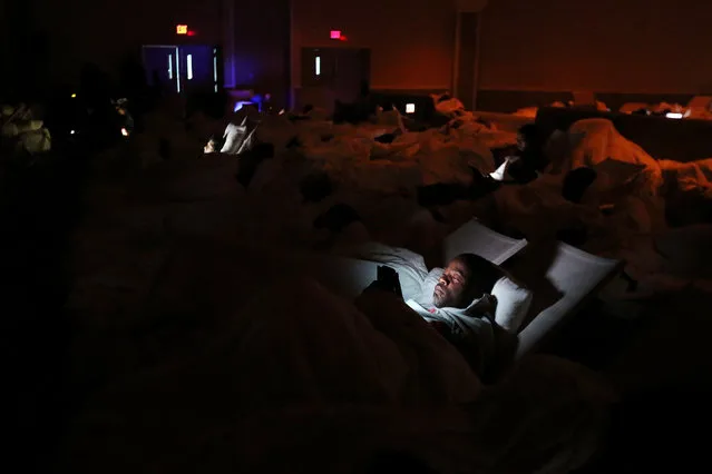 A man reads updates about Hurricane Matthew on his smartphone as he takes shelter in a ballroom of the Melia Hotel overnight in Nassau, Bahamas October 5, 2016. (Photo by Carlos Garcia Rawlins/Reuters)