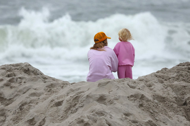 A woman and a child watch waves in the Atlantic Ocean, during the first hurricane of the 2025 Atlantic season, named Erin, in Long Beach, New York on August 20, 2025. (Photo by Shannon Stapleton/Reuters)