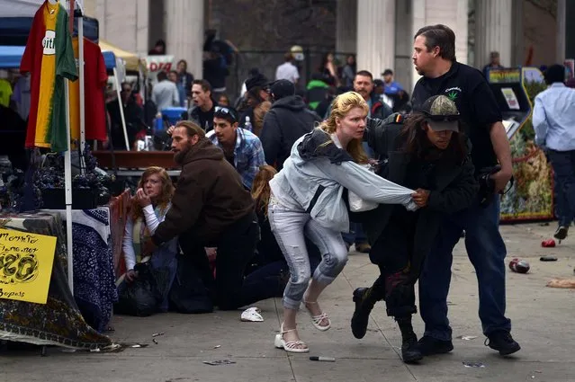 People hide and run away from the gun shots at Civic Center Park after the 4/20 pot rally, Saturday, April 20, 2013 in Denver. Gunfire erupted at a Denver pot celebration Saturday, injuring two people and scattering a crowd of thousands who had gathered for the first 4/20 counterculture holiday since the state legalized marijuana. (Photo by Joe Amon/AP Photo/The Denver Post)