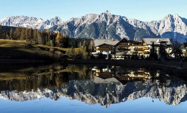 Mountains are reflected in a small lake on a sunny autumn day in the western Austrian village of Seefeld, west of Innsbruck November 23, 2014. (Photo by Dominic Ebenbichler/Reuters)