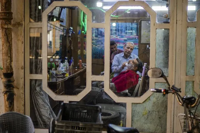A man has his beard shaved by a barber in Fallujah, Iraq, on Thursday, March 2, 2023. (Photo by Jerome Delay/AP Photo)