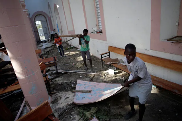 Boys clear a church from debris after Hurricane Matthew in Les Anglais, Haiti, October 13, 2016. (Photo by Andres Martinez Casares/Reuters)