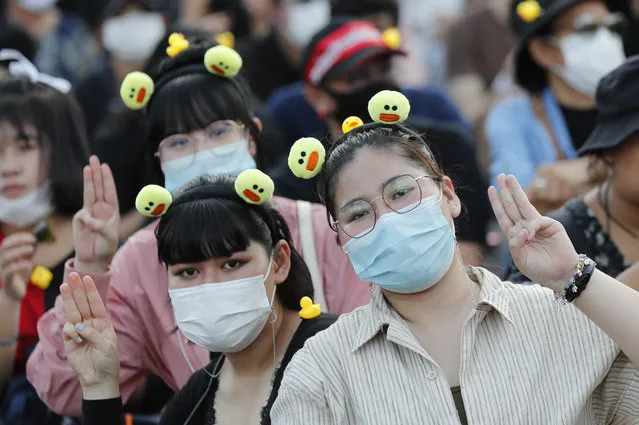 Protesters flash the three-finger protest gesture during a rally Wednesday, November 25, 2020, in Bangkok Thailand. (Photo by Sakchai Lalit/AP Photo)