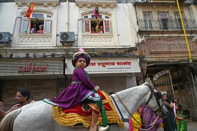 A child dressed in traditional attire and finery takes part in a procession celebrating “Gudi Padwa” or the Maharashtrian New Year, in Mumbai on March 22, 2023. (Photo by Indranil Mukherjee/AFP Photo)