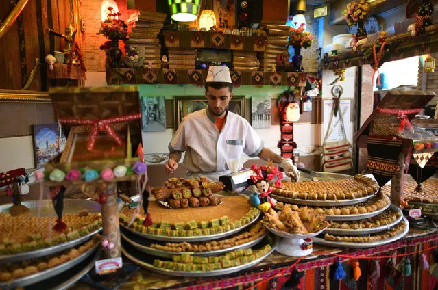 A man prepares sweet pastries in a shop in Erbil bazaar on October 26, 2016 in Erbil, Iraq. As the offensive by Iraqi and Kurdish forces to drive Islamic State out of Iraq's second largest city of Mosul continues and despite a recent ISIS attack on nearby Kirkuk, life in Erbil, the de-facto capital of Iraq's northern Kurdish region, has carried on peacefully. (Photo by Carl Court/Getty Images)
