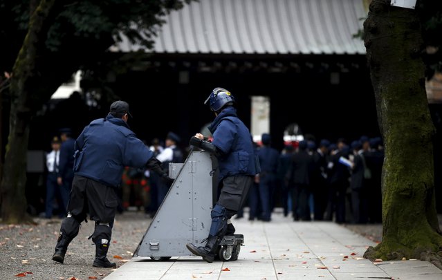 Members of a police bomb disposal squad move a blast protection device to the site of an explosion at the Yasukuni shrine in Tokyo, Japan, November 23, 2015. (Photo by Toru Hanai/Reuters)