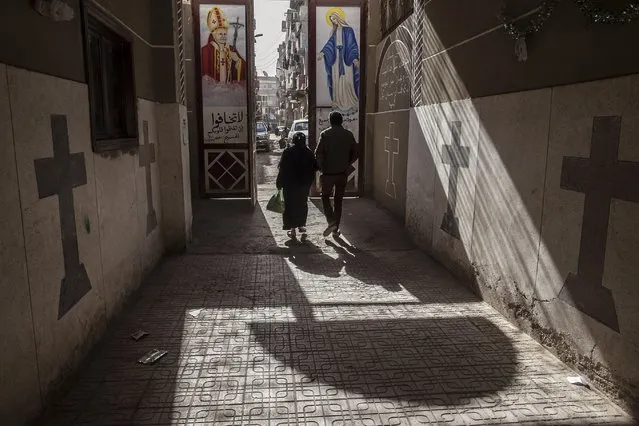 Coptic Christians walk outside St. Markos Church in Minya, south of Cairo, Egypt, where two policemen guarding the church were shot dead by unknown gunmen on the early hours of Tuesday, January 6,. 2015, a day before Egypt's Coptic Christmas falls. Security is typically tightened at churches around Egypt ahead of the holiday. (Photo by Roger Anis/AP Photo)