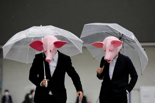 Youtubers wearing masks of pigs film a video at a shopping district which has fewer people than usually amid the coronavirus disease (COVID-19) outbreak in Tokyo, Japan, May 19, 2020. (Photo by Kim Kyung-Hoon/Reuters)