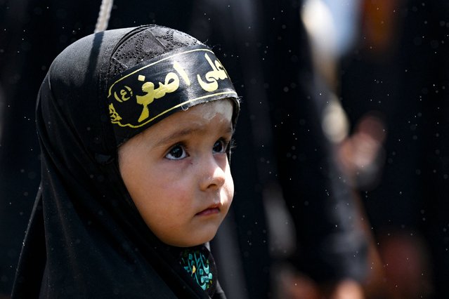 A Shiite Muslim girl looks on during a religious procession on the tenth day of the Islamic month of Muharram, in Srinagar, India on July 17, 2024. (Photo by Tauseef Mustafa/AFP Photo)