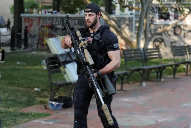 A U.S. Secret Service counter assault team member carries a sniper rifle through Lafayette Park as U.S. President Donald Trump holds a photo opportunity in front of St. John's Episcopal Church across from the White House during ongoing protests over racial inequality in the wake of the death of George Floyd while in Minneapolis police custody, outside the White House in Washington, U.S., June 1, 2020. (Photo by Tom Brenner/Reuters)