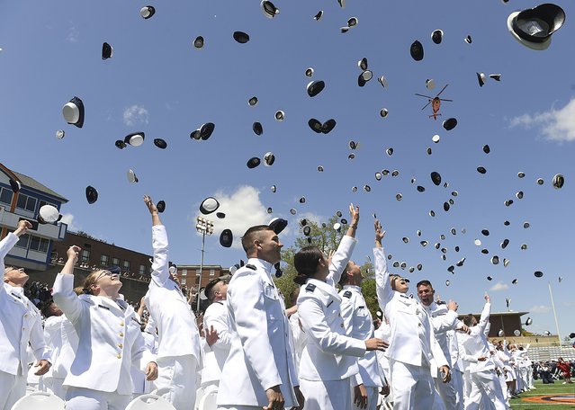 Coast Guard ensigns toss their caps in celebration as Coast Guard helicopters perform a flyover during the United States Coast Guard Academy commencement ceremony, Wednesday, May 17, 2023, in New London, Conn. (Photo by Dana Jensen/The Day via AP Photo)