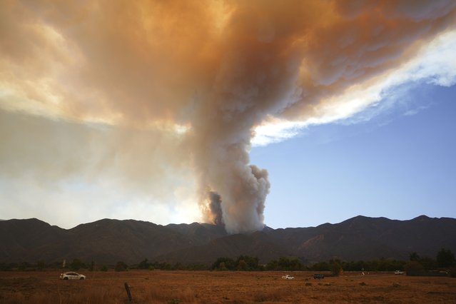 A plume of smoke created by the Airport Fire is seen on a mountain top Tuesday, September 10, 2024, in Temescal Valley, Calif. (Photo by Eric Thayer/AP Photo)