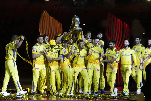 Players of Chennai Super Kings celebrate with the winners trophy after their win in the Indian Premier League final cricket match against Gujarat Titans in Ahmedabad, India, Tuesday, May 30, 2023. (Photo by Ajit Solanki/AP Photo)