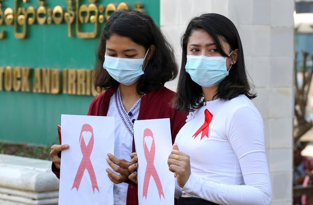 Government staff wearing red ribbons pose during a protest against the coup that ousted elected leader Aung San Suu Kyi in Naypyitaw, Myanmar on February 4, 2021. (Photo by Reuters/Stringer)