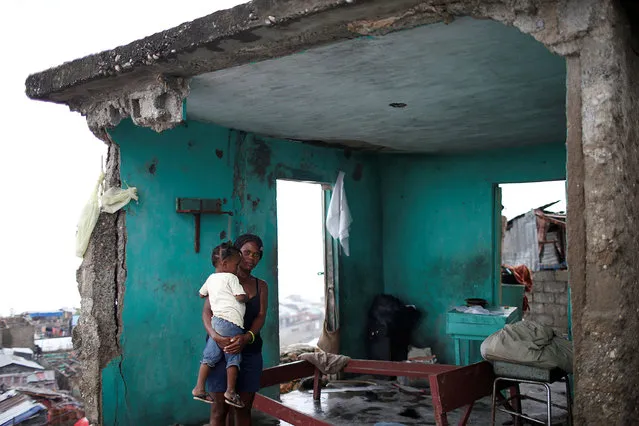 Nathalie Pierre, 28, poses for a photograph with her daughter Rose, 3, in their destroyed house after Hurricane Matthew hit Jeremie, Haiti, October 17, 2016. “As you can see, my situation is very bad. I lost all I had; my house, my money, my boutique. Everything gone in a few minutes. The storm was terrible but I was lucky to have my only daughter alive – that's the most important thing. Life goes on”, said Pierre. (Photo by Carlos Garcia Rawlins/Reuters)