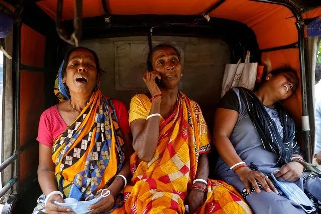 Relatives of train collision victims react as they sit in an autorickshaw outside a temporary mortuary created in a business park, following the train collision in Balasore district in the eastern state of Odisha, India on June 4, 2023. (Photo by Adnan Abidi/Reuters)