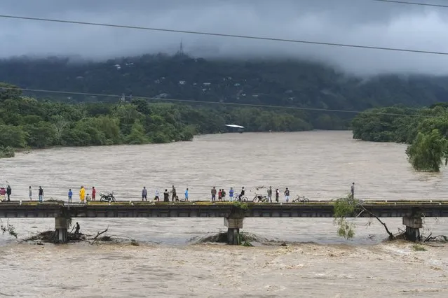 People watch the Humuya river flooding due to heavy rains caused by Eta Hurricane, in Santa Rita, Yoro department, 240 km northern Tegucigalpa, on November 3, 2020. Honduras' authorities reported a small girl died when a house collapsed in San Pedro Sula where Eta caused flooding and forced hundreds of people to evacuate their homes. Eta is forecast to move inland over northern Nicaragua and central Honduras through Wednesday and into Thursday. (Photo by Orlando Sierra/AFP Photo)