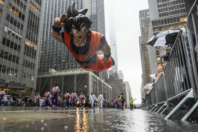 Handlers guide the Goku balloon down Sixth Avenue during the Macy's Thanksgiving Day Parade, in New York, November 28, 2024. (Photo by Julia Demaree Nikhinson/AP Photo)