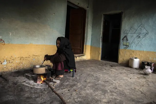 A girl cooks over a wood-burning fire at her house on Margalla Hills in Islamabad January 22, 2015. (Photo by Zohra Bensemra/Reuters)