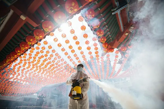 A healthcare worker dressed in a protective suit sprays disinfectants at the Thean Hou Temple during the Lunar New Year in Kuala Lumpur, Malaysia on February 12, 2021. (Photo by Annice Lyn/SOPA Images/LightRocket via Getty Images)