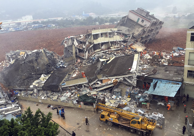 Rescuers search for survivors amongst collapsed buildings after a landslide in Shenzhen, in south China's Guangdong province, Sunday December 20, 2015. The landslide collapsed and buried buildings at and around an industrial park in the southern Chinese city of Shenzhen on Sunday authorities reported. (Photo by Chinatopix via AP Photo)