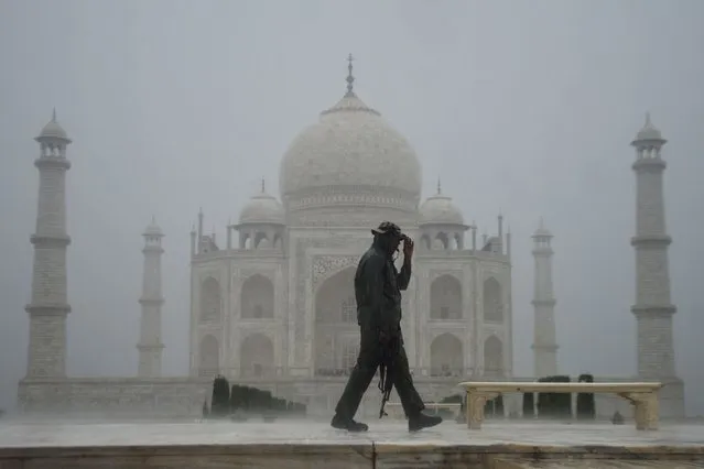 A Central Industrial Security Force (CISF) officer patrols at the Taj Mahal during a heavy rainfall in Agra on July 4, 2023. (Photo by Pawan Sharma/AFP Photo)