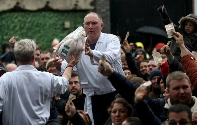 Butchers sell their remaining produce of the year at discounted prices during the traditional Christmas Eve auction at Smithfield's market in London December 24, 2015. (Photo by Neil Hall/Reuters)