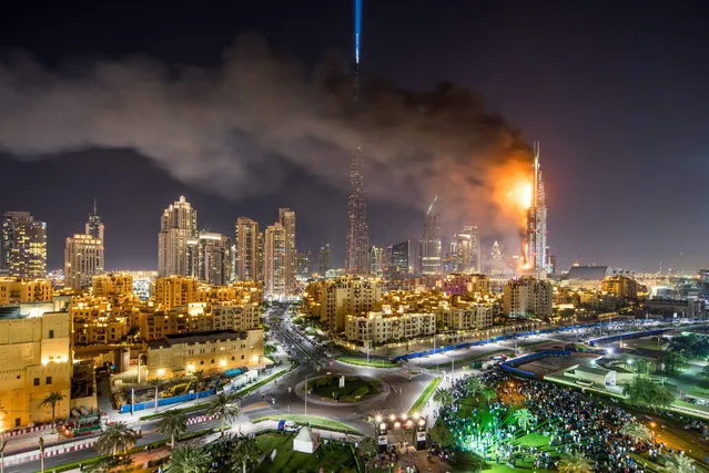 A general view of flames and smoke billowing from the building after fire broke out at The Address Hotel in Dubai, UAE 31 December 2015. Media reports state that there is no immediate news of casualties. (Photo by Nicolas Cornet/EPA)