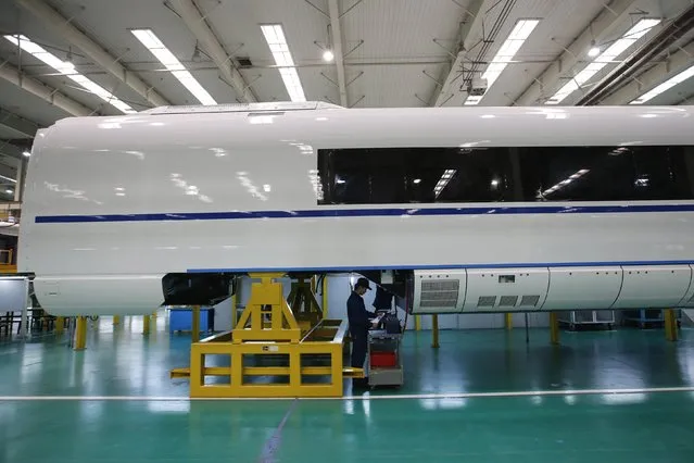 An employee works on a final assembly line for CRH380B, a high speed train model, at China CNR's Tangshan Railway Vehicle's factory in Tangshan, Hebei province, February 11, 2015. (Photo by Kim Kyung-Hoon/Reuters)