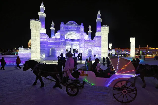 People visit the ice sculptures illuminated by coloured lights at Harbin ice and snow world during the opening ceremony of the 32nd Harbin International Ice and Snow Festival in Harbin city, China's northern Heilongjiang province, 05 January 2016. (Photo by Wu Hong/EPA)
