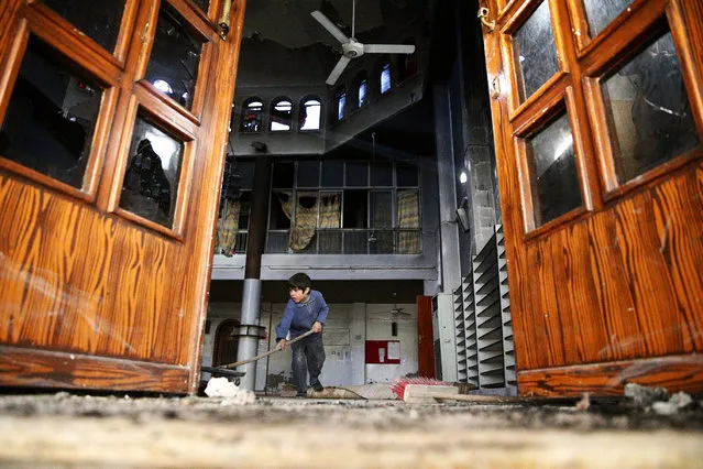 A boy cleans a damaged mosque at a site hit yesterday by an airstrike in the rebel held besieged Douma neighbourhood of Damascus, Syria November 24, 2016. (Photo by Bassam Khabieh/Reuters)