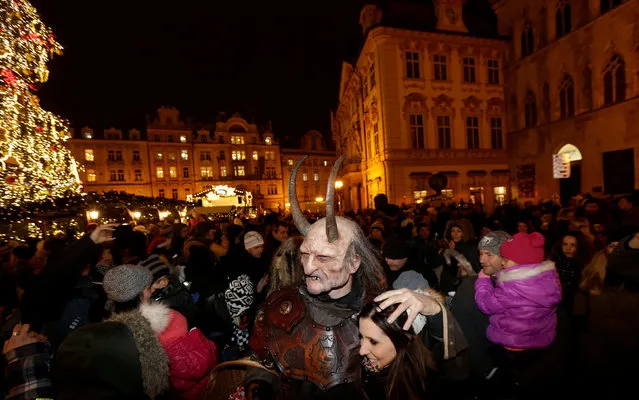 A reveller dressed as a devil embraces a woman, on the eve of Saint Nicholas Day, at the Old Town Square in Prague, Czech Republic December 5, 2016. (Photo by David W. Cerny/Reuters)