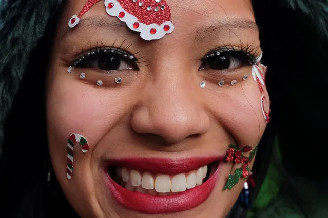 A reveller sports seasonal decorations on her face while taking part in the annual SantaCon event in Manhattan, New York, December 10, 2016. (Photo by Jeenah Moon/Reuters)