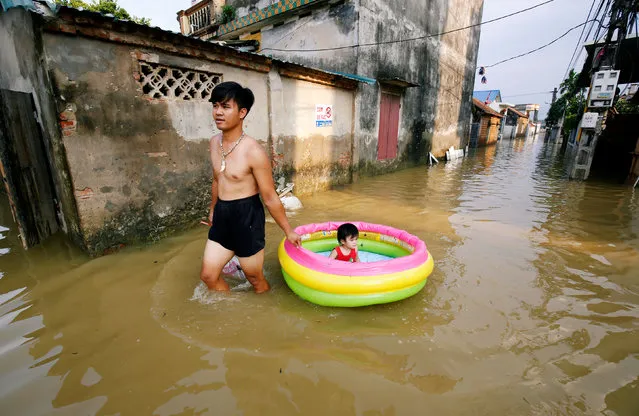 A man pulls his daughter on a flooded village after heavy rainfall caused by tropical storm Son Tinh outside Hanoi, Vietnam July 24, 2018. (Photo by Reuters/Kham)