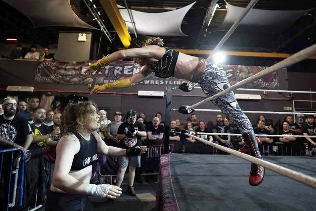 Professional wrestlers Helen Charlotte Campbell and Dark Sheik (R) compete during an evening of wrestling entertainment, presented by promoter “TNT Extreme Wrestling'” in Liverpool, northern England, on September 17, 2023. The event pitted UK-based wrestlers representing 'TNT Extreme Wrestling' against US wrestlers from “Game Changer Wrestling” and featured Helen Charlotte Campbell versus Dark Sheik, which is understood to be the first singles wrestling match between binary trans women in the UK. (Photo by Oli Scarff/AFP Photo)