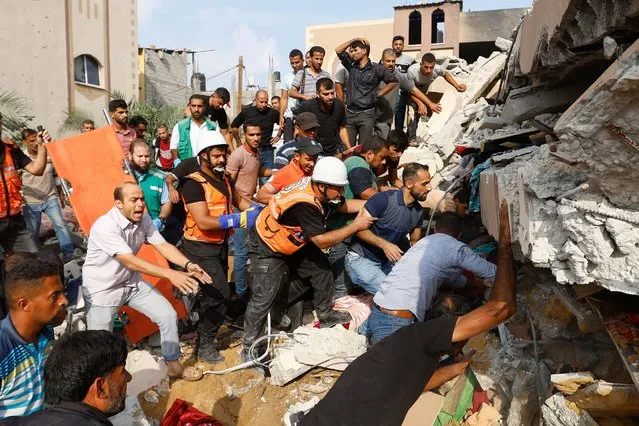 Palestinians search under the rubble of a house destroyed in Israeli strikes in Khan Younis, in the southern Gaza Strip on October 8, 2023. (Photo by Ibraheem Abu Mustafa/Reuters)