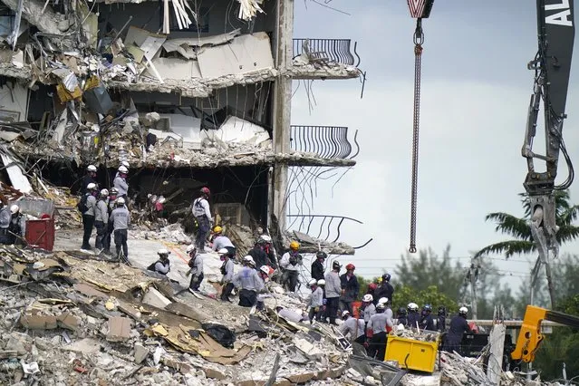 Rescue workers search in the rubble at the Champlain Towers South condominium, Monday, June 28, 2021, in the Surfside area of Miami. Many people are still unaccounted for after the building partially collapsed last Thursday. (Photo by Lynne Sladky/AP Photo)