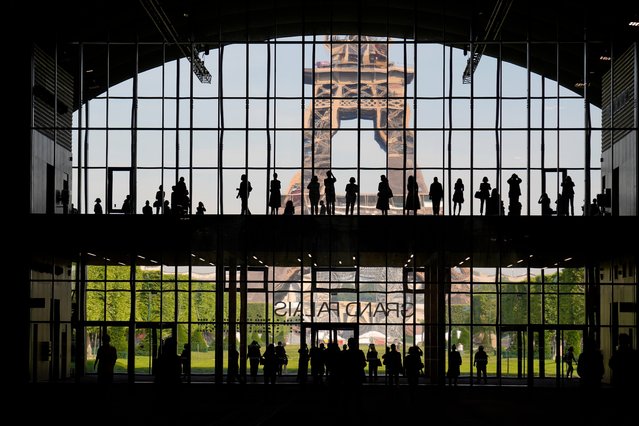 Visitors gather during a presentation visit of the “Grand Palais Ephemere”, with the Eiffel Tower seeing outside, in Paris, Wednesday, June 9, 2021. The Temporary Grand Palais, a temporary building designed by the architect Jean-Michel Wilmotte and built by GL Events, situated on the Champ-de-Mars next to the Eiffel Tower will be used until the end of the Paris 2024 Olympic and Paralympic Games. (Photo by Francois Mori/AP Photo)