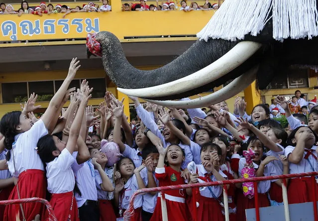 A Thai elephant dressed as Santa Claus distributes presents to students during Christmas celebrations at a school in the world heritage city of Ayutthaya, north of Bangkok, Thailand, 24 December 2018. The annual event is held every year for to celebrate the upcoming Christmas festive season and promote tourism in Ayutthaya. (Photo by Narong Sangnak/EPA/EFE)