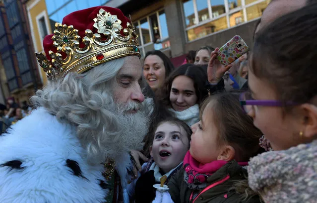 A man dressed as one of the Three Kings receives a baby pacifier from a girl during the Epiphany parade in Gijon, Spain January 5, 2017. (Photo by Eloy Alonso/Reuters)