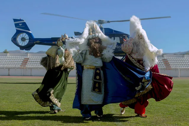 Men dressed up as Balthasar, Gaspar and Melchior, the Three Wise Men, protect themselves from the wind of a helicopter after arriving in it to participate in the Epiphany parade in Ronda, near Malaga, southern Spain January 5, 2019. (Photo by Jon Nazca/Reuters)