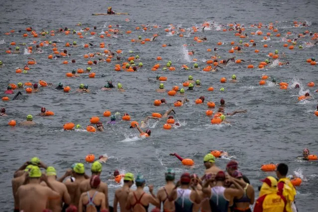 Participants take part in the Harbour Race, where swimmers cross Hong Kong's Victoria Harbour, in the city on November 12, 2023. (Photo by Isaac Lawrence/AFP Photo)