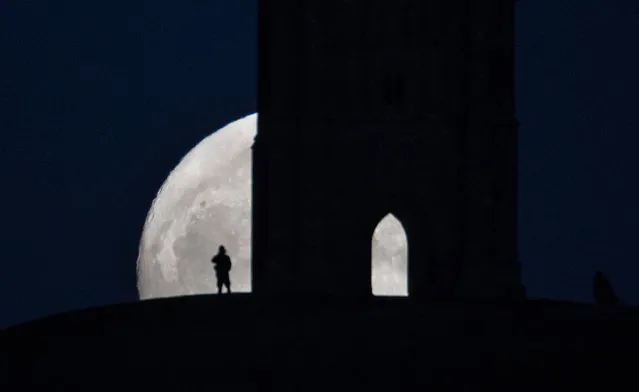 A so-called wolf moon rises over Glastonbury Tor on January 11, 2017 in Somerset, England. In some parts of the world, the January full moon is nicknamed the wolf moon, which dates back to the days when native American tribes gave names to each month's full moon to help keep track of the seasons. The full moon was visible ahead of a forecast for wind and snow hitting parts of the UK tomorrow. (Photo by Matt Cardy/Getty Images)