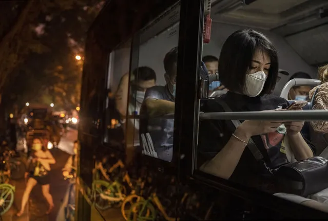 Commuters wear masks to protect against COVID-19 as they sit on a public bus as it waits to depart during the evening rush hour on August 4, 2021 in Beijing, China. (Photo by Kevin Frayer/Getty Images)