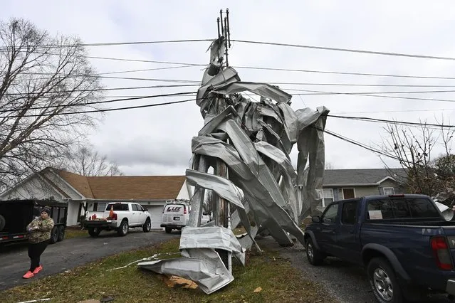 Metal roofing from a nearby church is wrapped around a utility pole, Sunday, December 10, 2023, in Clarksville, Tenn. Tornados caused catastrophic damage in Middle Tennessee on Saturday afternoon and evening, Dec. 9. (Photo by Mark Zaleski/AP Photo)