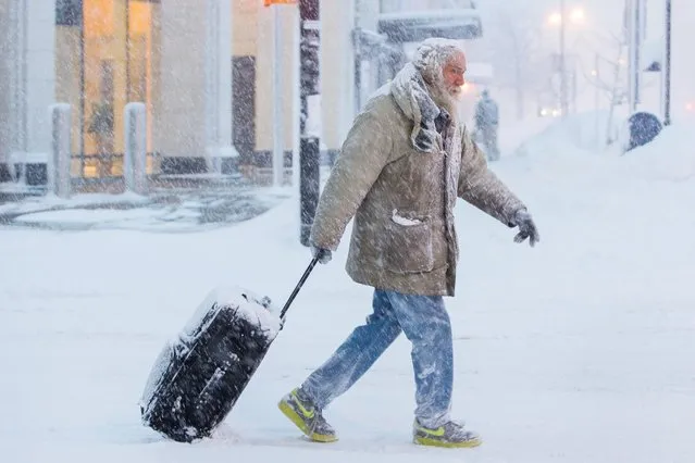 Man moves luggage in snow during a winter storm in Buffalo, New York, U.S., January 30, 2019. (Photo by Lindsay Dedario/Reuters)
