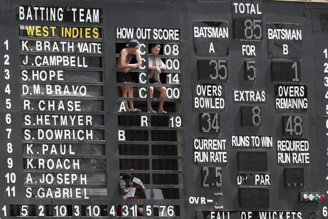 From the scoreboard, spectators watch day four of the third cricket Test match between England and West Indies at the Daren Sammy Cricket Ground in Gros Islet, St. Lucia, Tuesday, February 12, 2019. (Photo by Ricardo Mazalan/AP Photo)