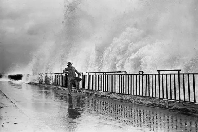 A man on the Belt Parkway seawall near Brooklyn’s Fort Hamilton braces for impact as a wall of water looms above him in this picture taken in October 1948. Published as a Flashback in the September issue of National Geographic magazine, parts of the area were inundated again when Hurricane Sandy roared ashore in October 2012. (Photo by New York Daily News/National Geographic)