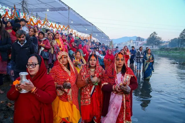 Nepali Hindu devotees take dip in the Bagmati River making offerings to rising Sun on fourth day of festival of Chatth on November 20, 2023. The festival dedicated to Sun is observed for 4 days in Nepal where people undergo arduous fasting praying and seeking blessings with a wish. Mostly the female members of the family undergo arduous fasting praying for the well-being of the family and long life of their husband. (Photo by Subash Shrestha/Rex Features/Shutterstock)